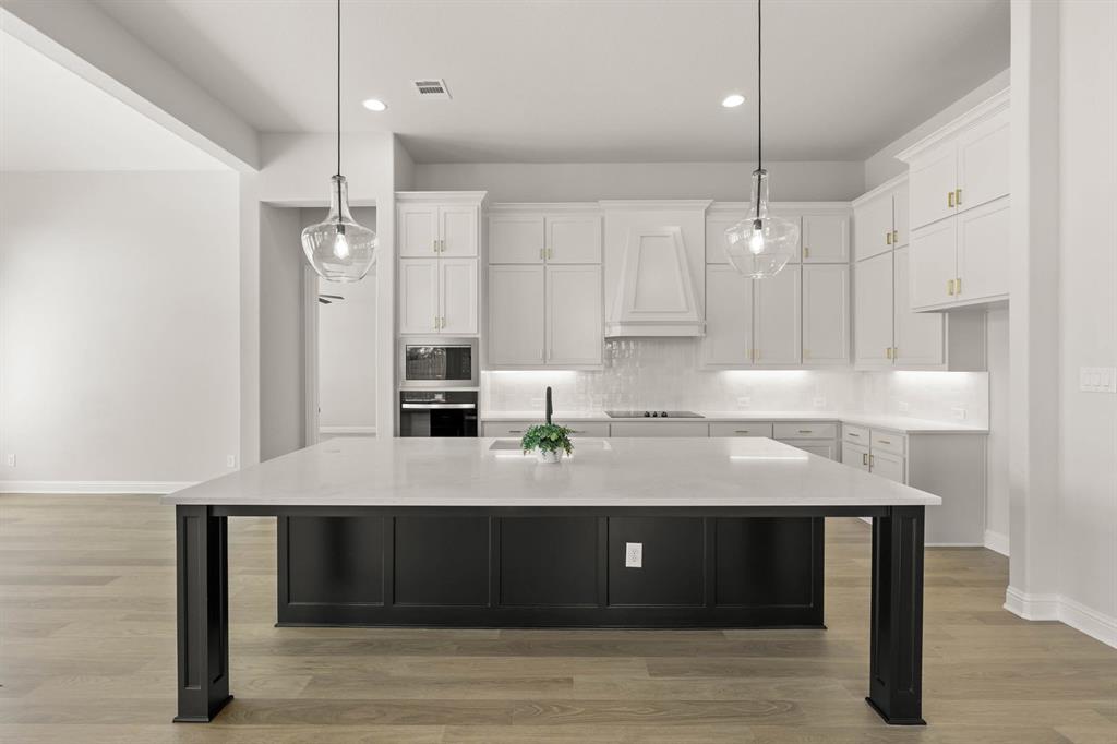 5210 Rowlan Row Midlothian, TX 76065 - Photo 16 of 40 a kitchen with kitchen island stainless steel appliances a table chairs sink and stove top oven