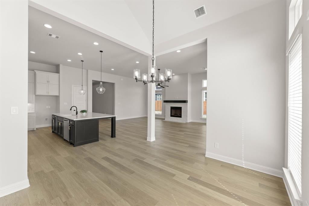 5210 Rowlan Row Midlothian, TX 76065 - Photo 27 of 40 a living room with kitchen island furniture and a chandelier