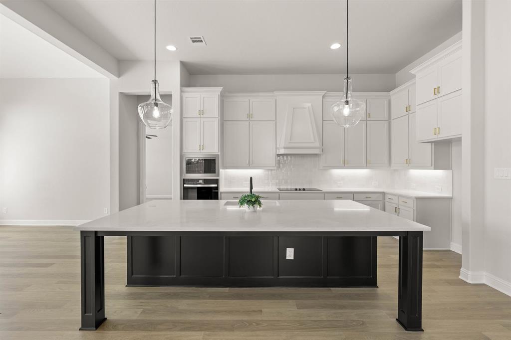 5210 Rowlan Row Midlothian, TX 76065 - Photo 28 of 40 a kitchen with kitchen island stainless steel appliances a table chairs sink and stove top oven