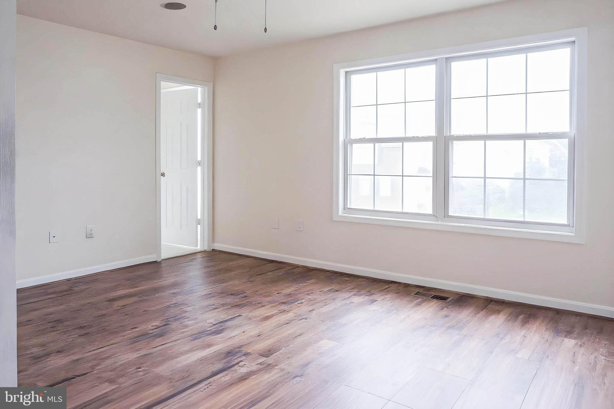 8461 Tackhouse Loop Gainesville, VA 20155 - Photo 12 of 39 an empty room with wooden floor and windows