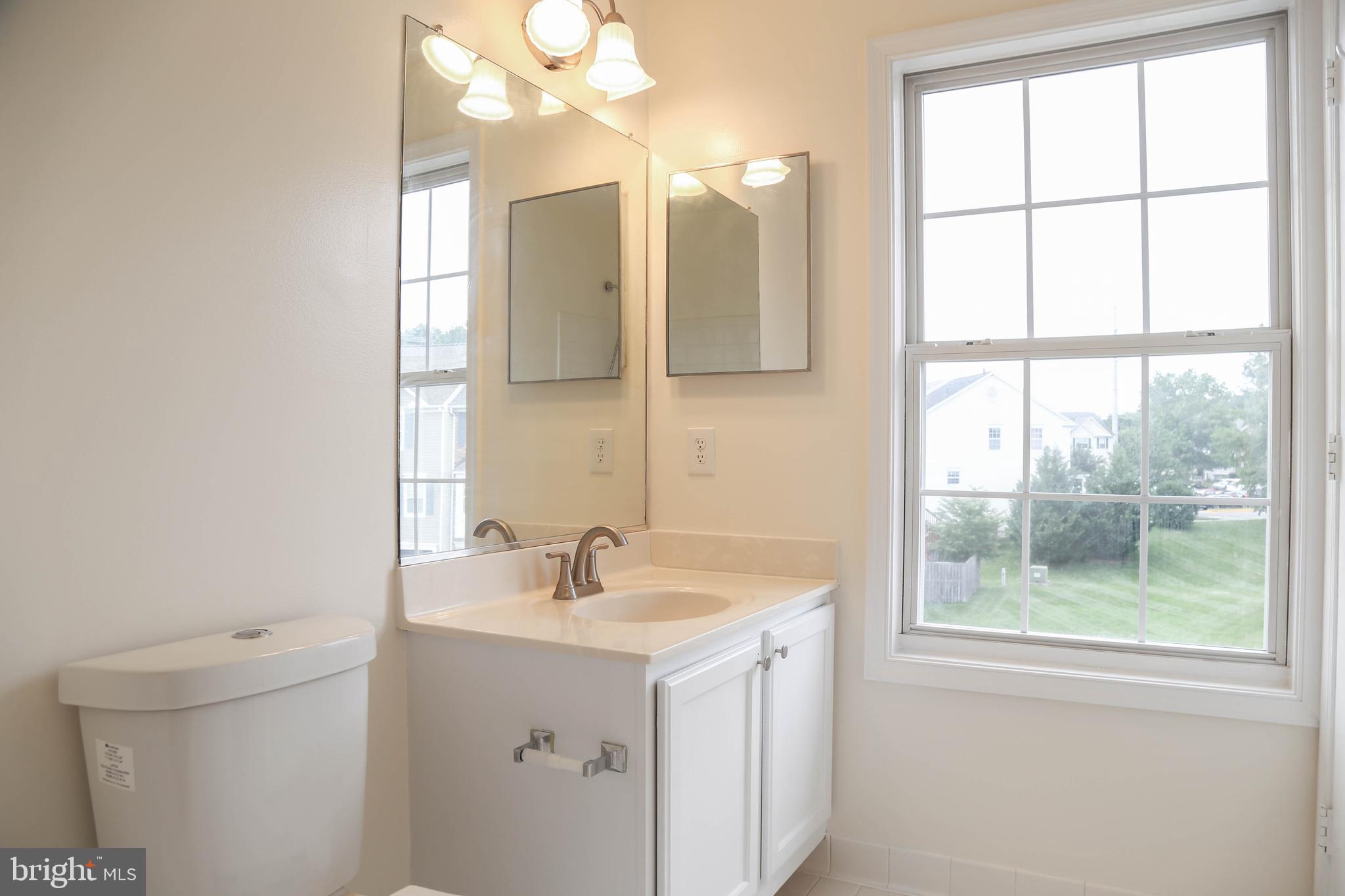 8461 Tackhouse Loop Gainesville, VA 20155 - Photo 18 of 39 a bathroom with a sink a vanity and a mirror