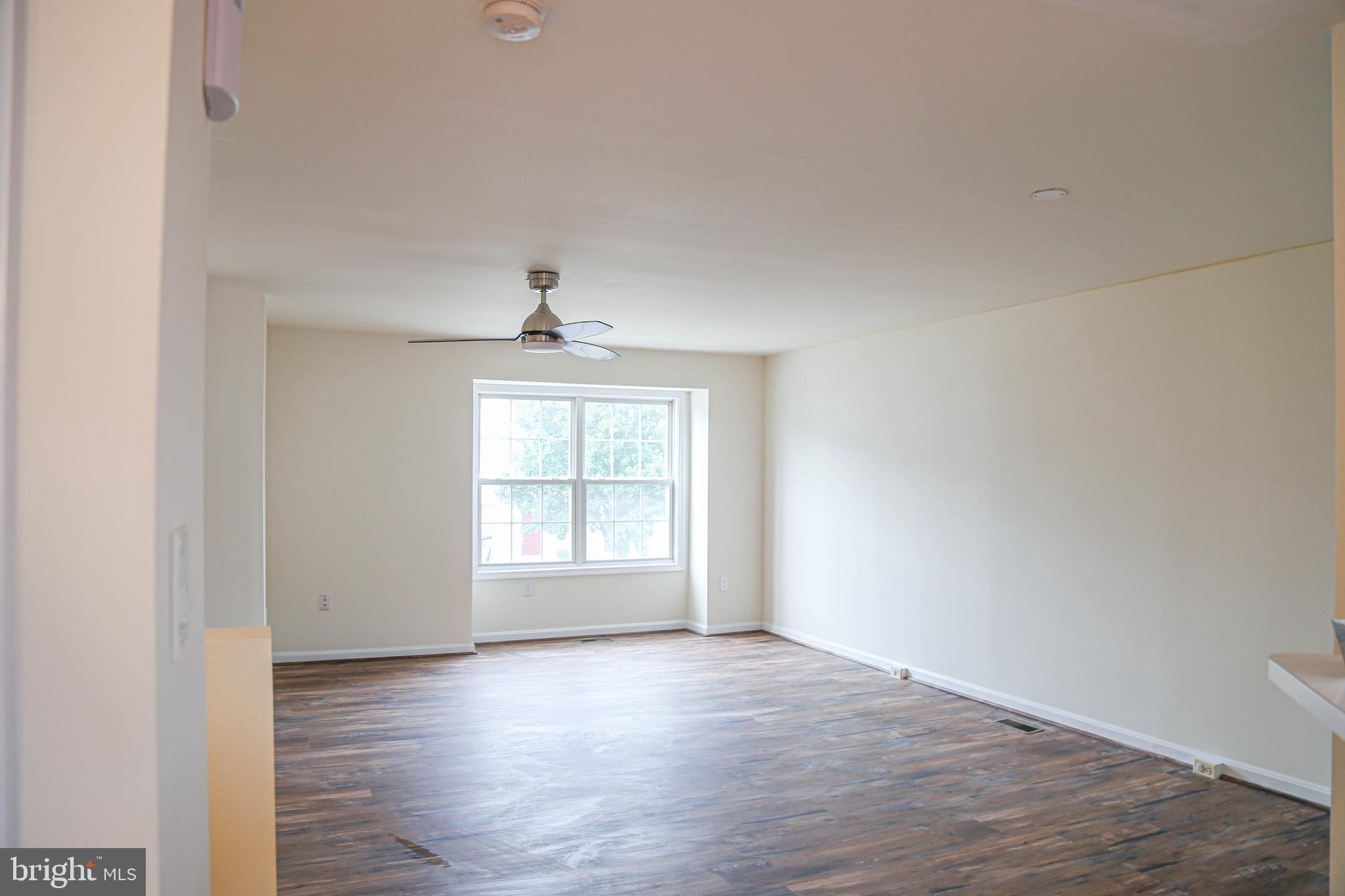 8461 Tackhouse Loop Gainesville, VA 20155 - Photo 3 of 39 an empty room with wooden floor cabinet and windows