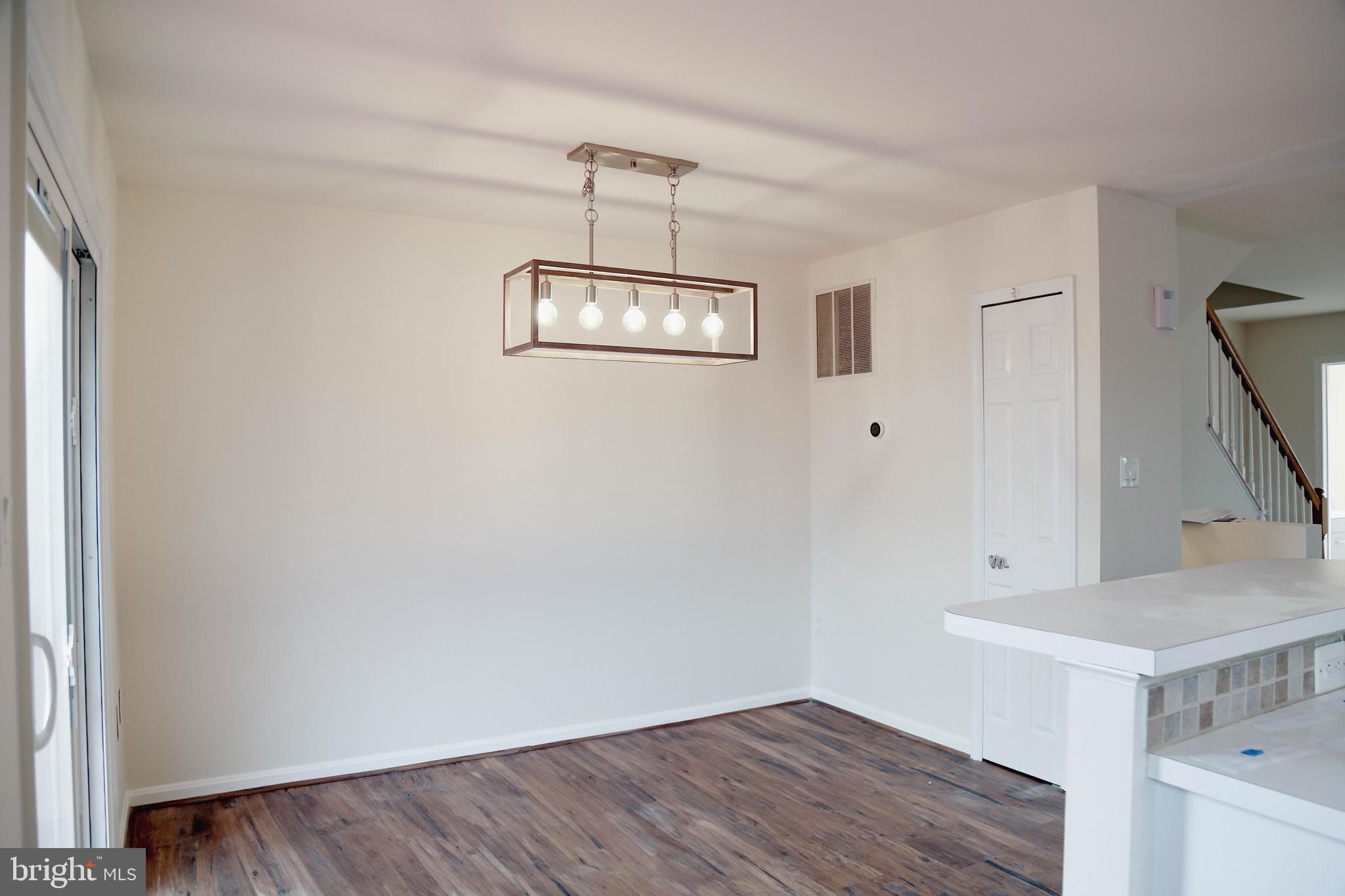 8461 Tackhouse Loop Gainesville, VA 20155 - Photo 7 of 39 a view of a room with wooden floor and chandelier