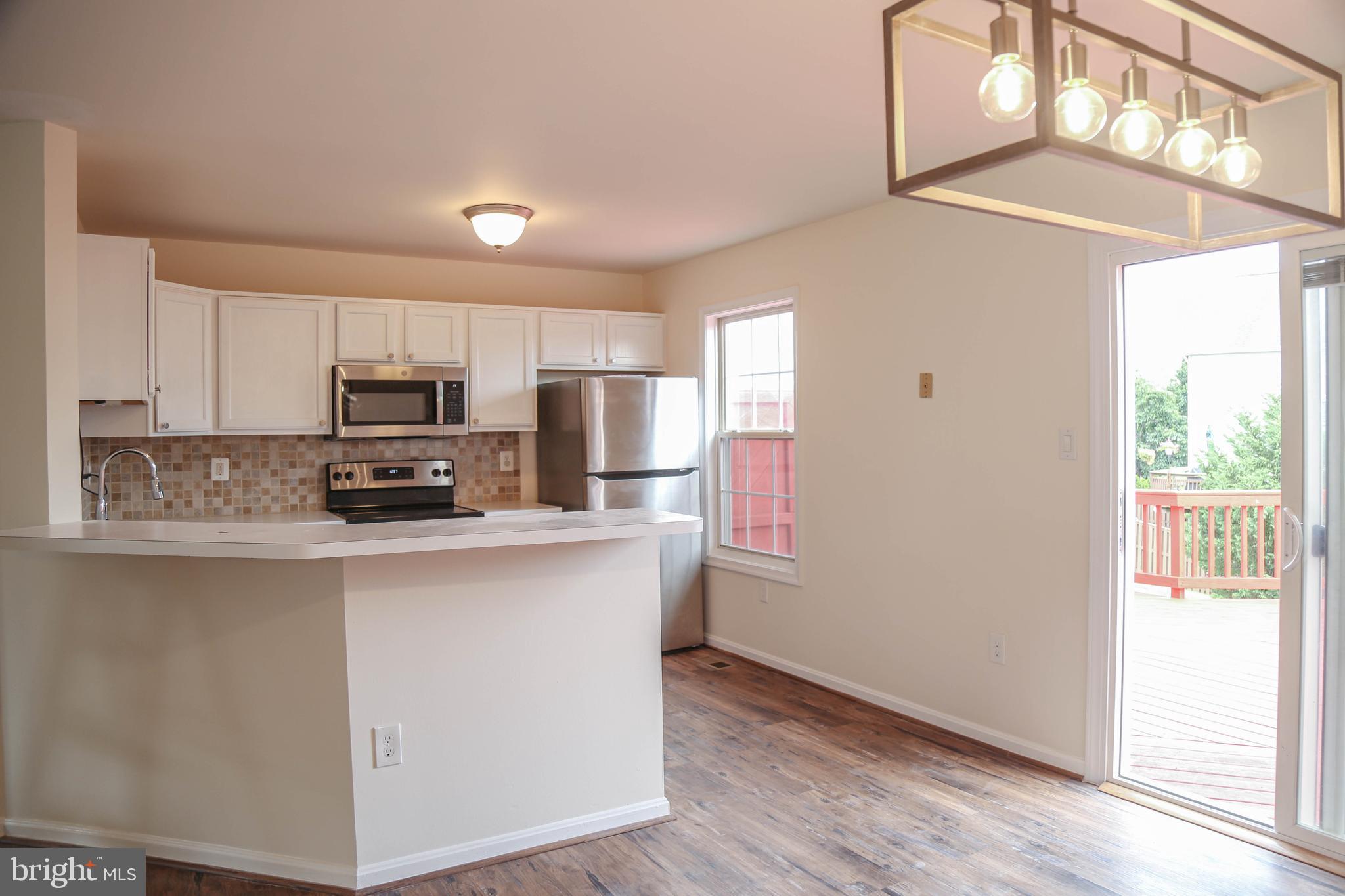 8461 Tackhouse Loop Gainesville, VA 20155 - Photo 9 of 39 a kitchen with stainless steel appliances a refrigerator sink and microwave