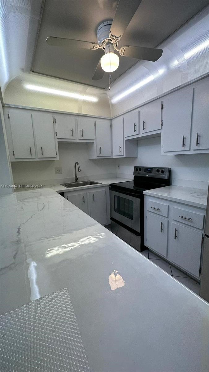 4174 Inverrary Drive, Unit 311 Lauderhill, FL 33319 - Photo 12 of 29 a kitchen with stainless steel appliances granite countertop a sink a stove and cabinets