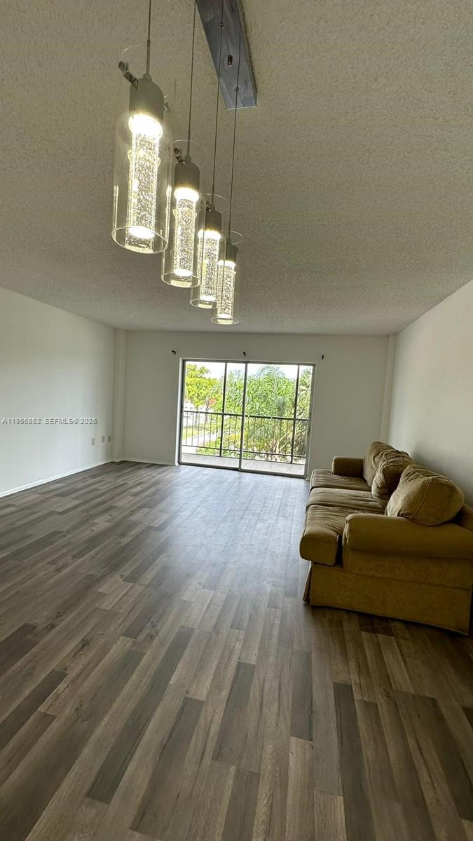 4174 Inverrary Drive, Unit 311 Lauderhill, FL 33319 - Photo 13 of 29 a living room with furniture and a chandelier