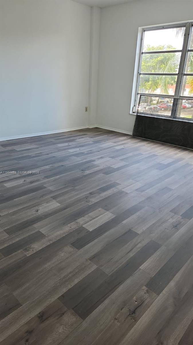 4174 Inverrary Drive, Unit 311 Lauderhill, FL 33319 - Photo 9 of 29 an empty room with wooden floor and windows