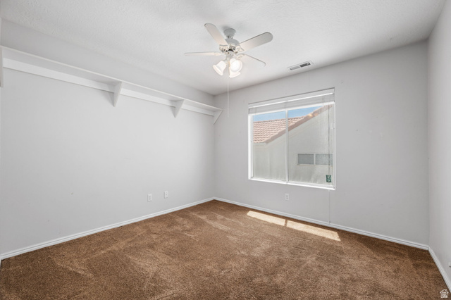 39 North Valley View Drive, Unit 51 St. George, UT 84770 - Photo 18 of 25 Neutral-toned room featuring a ceiling fan with integrated lighting, a large window with blinds, and white shelving along one wall