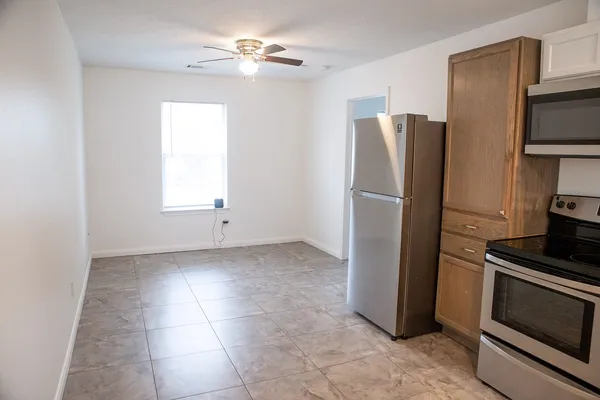 an empty room with a fireplace and a ceiling fan
