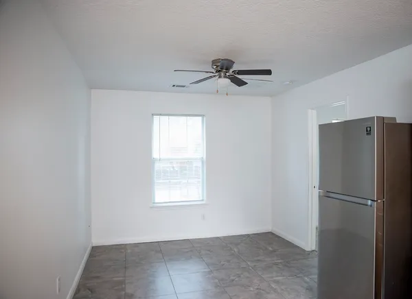 a view of a refrigerator in kitchen and a window