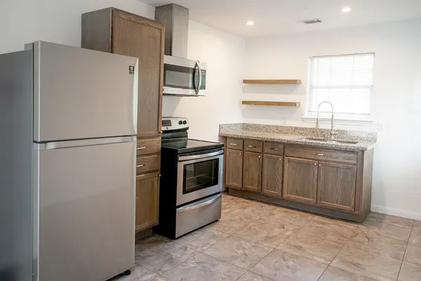 a kitchen with stainless steel appliances a refrigerator sink and cabinets