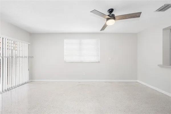 an empty room with a window and a ceiling fan