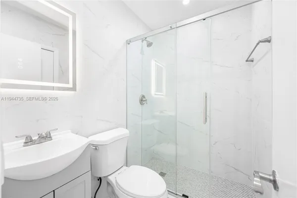 a white toilet sitting next to a bathroom sink