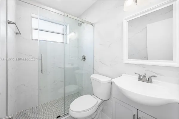 a white toilet sitting next to a bathroom sink