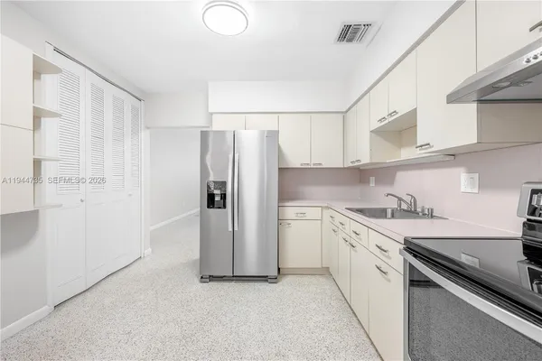 a kitchen with stainless steel appliances a sink cabinets and a refrigerator
