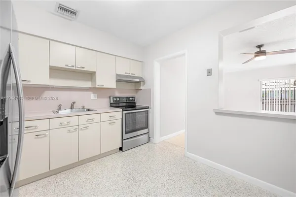 a kitchen with granite countertop white cabinets and white appliances