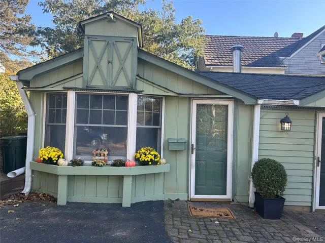 a front view of a house with a garden and plants