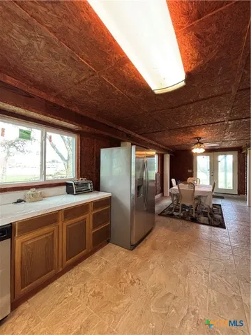 a kitchen with stainless steel appliances granite countertop a refrigerator a sink a stove with wooden cabinets