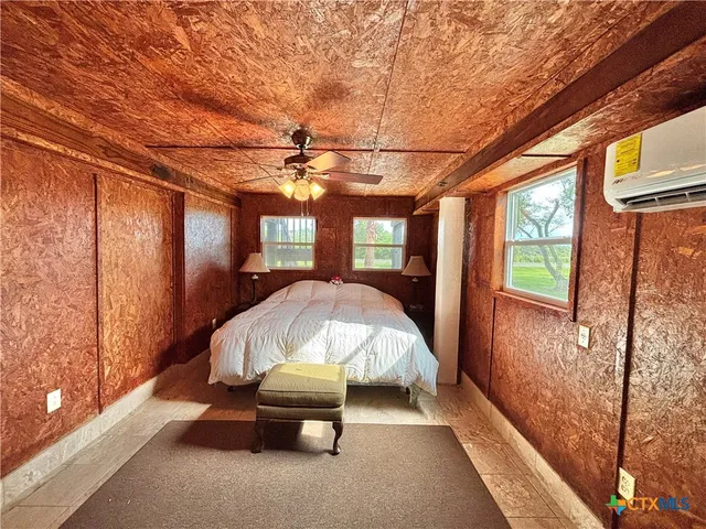 a bed sitting in a spacious bedroom next to a window