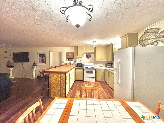 a kitchen with stainless steel appliances granite countertop a refrigerator and a stove top oven