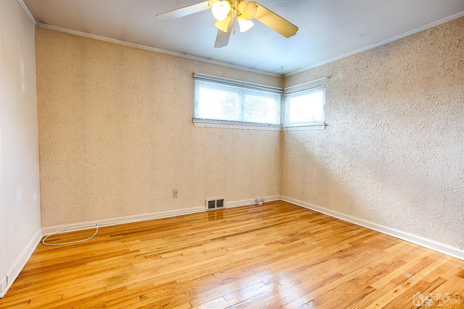 24 Longfield Road New Brunswick, NJ 08901 - Photo 9 of 27 a view of empty room with wooden floor and fan