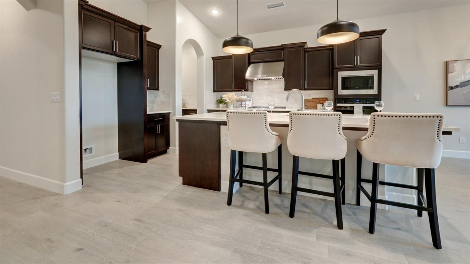 935 Talus Way Madera, CA 93636 - Photo 4 of 34 a kitchen with stainless steel appliances kitchen island granite countertop a table and chairs in it
