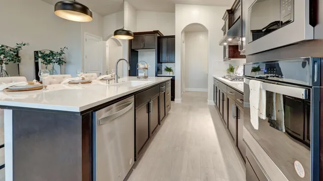 a kitchen with stainless steel appliances granite countertop a sink and a stove top oven