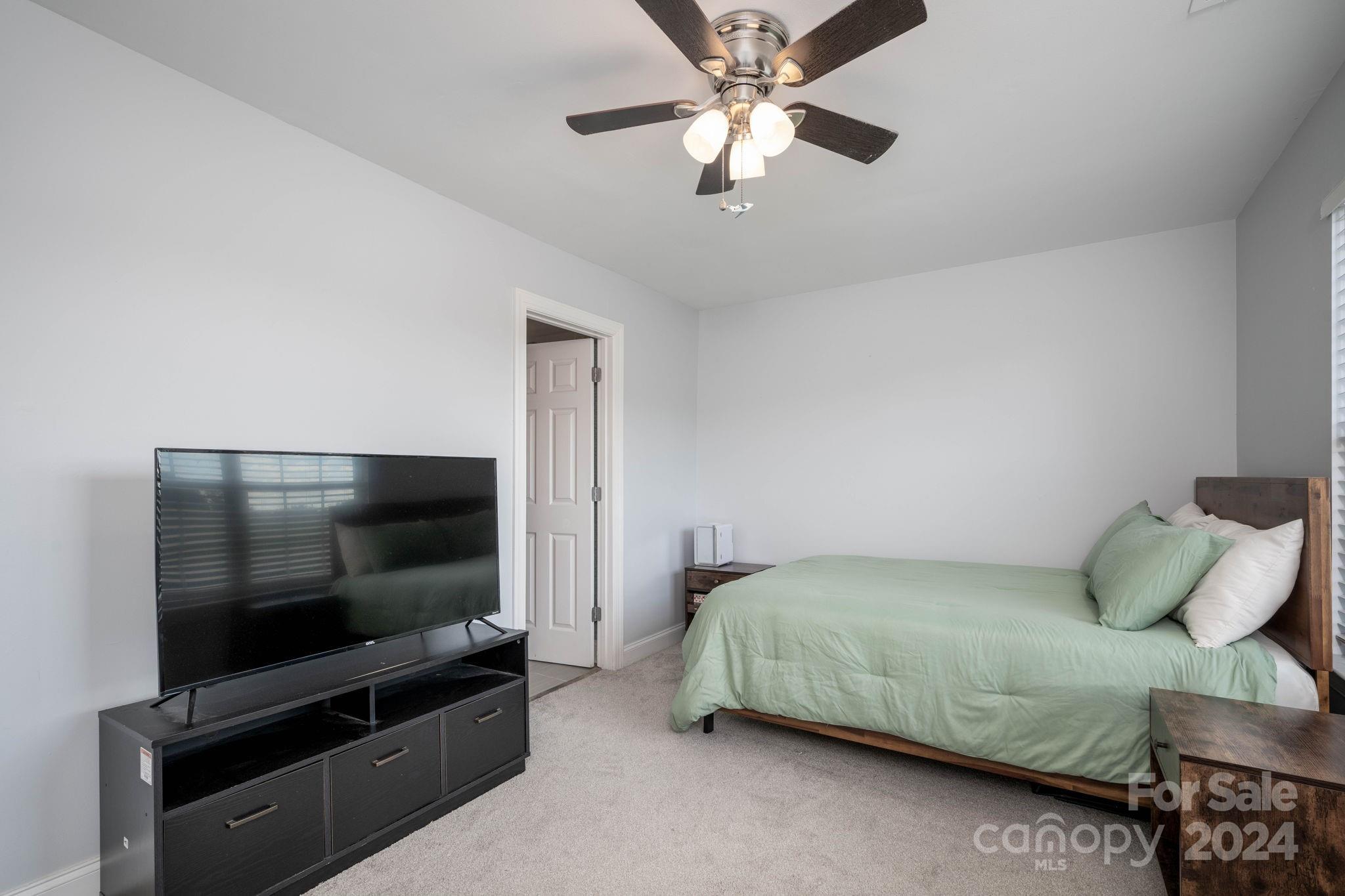 147 High Ridge Road Mooresville, NC 28117 - Photo 22 of 30 a bedroom with a bed and a flat screen tv