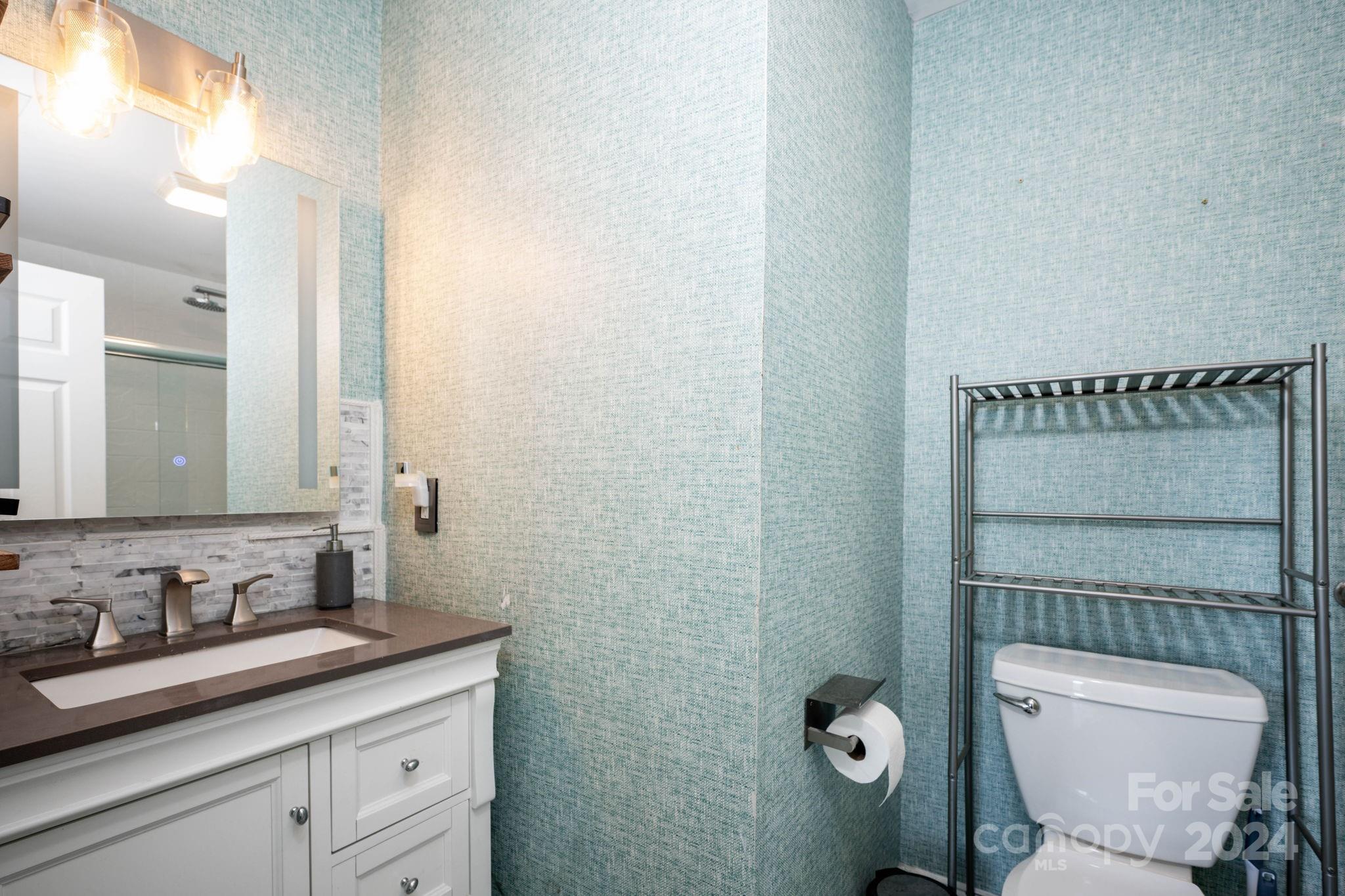 147 High Ridge Road Mooresville, NC 28117 - Photo 24 of 30 a bathroom with a granite countertop toilet a sink and a mirror