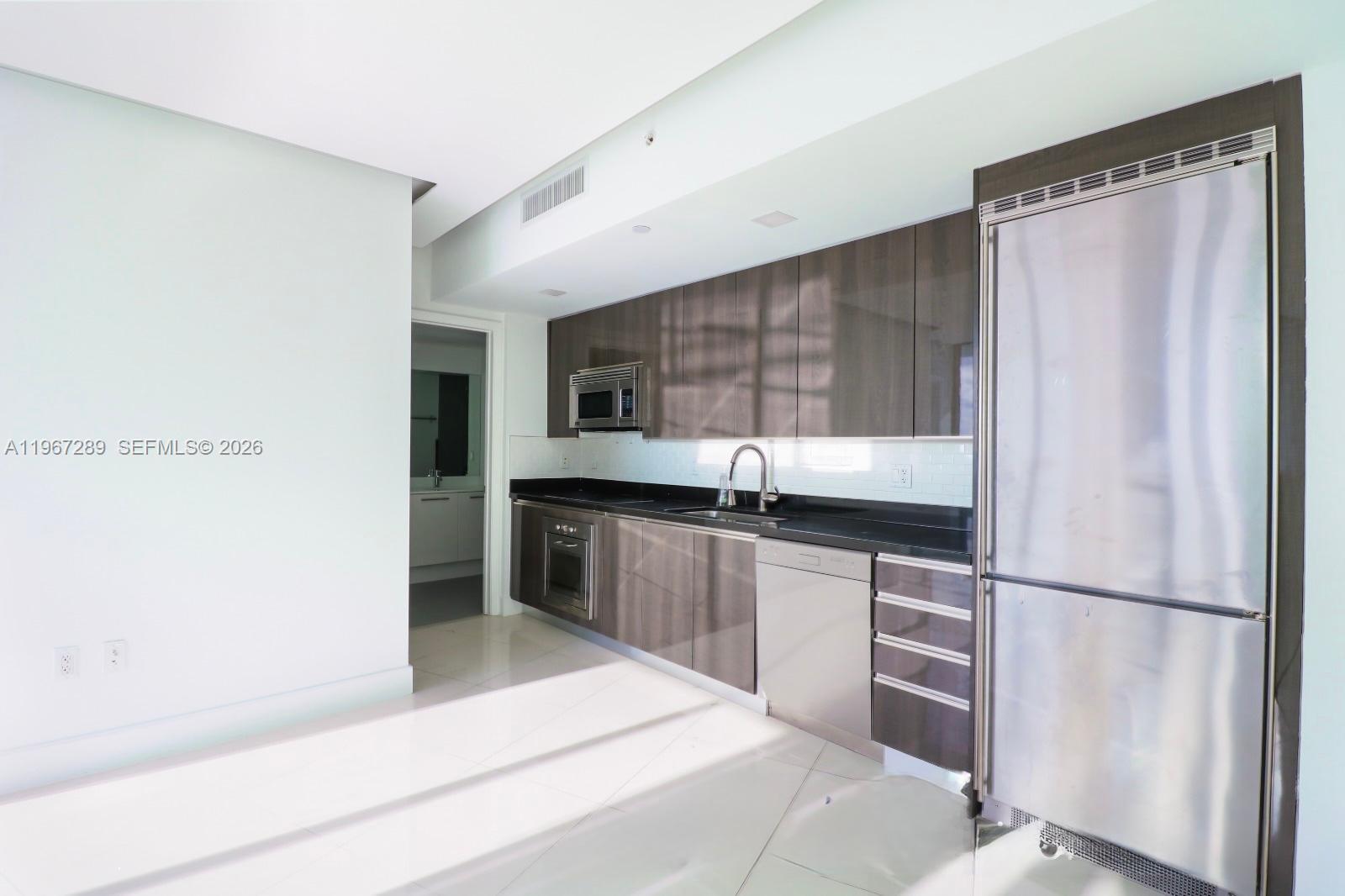 92 Southwest 3rd Street, Unit 2706 Miami, FL 33130 - Photo 12 of 13 a kitchen with stainless steel appliances granite countertop a refrigerator and a sink