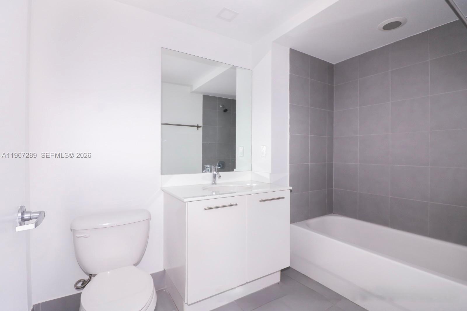 92 Southwest 3rd Street, Unit 2706 Miami, FL 33130 - Photo 6 of 13 a bathroom with a toilet a sink and bathtub