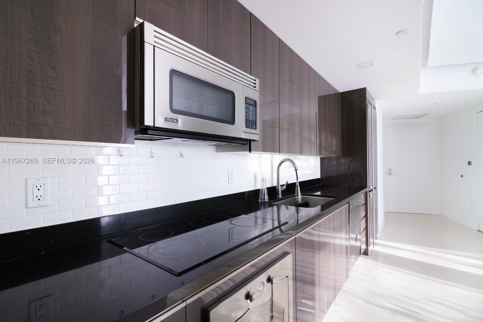 92 Southwest 3rd Street, Unit 2706 Miami, FL 33130 - Photo 9 of 13 a kitchen with a sink and microwave