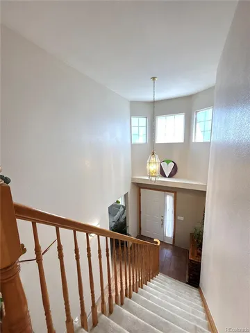 a view of a hallway with windows and chandelier