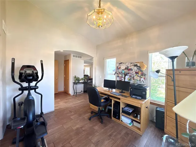 a view of a workspace with furniture and wooden floor