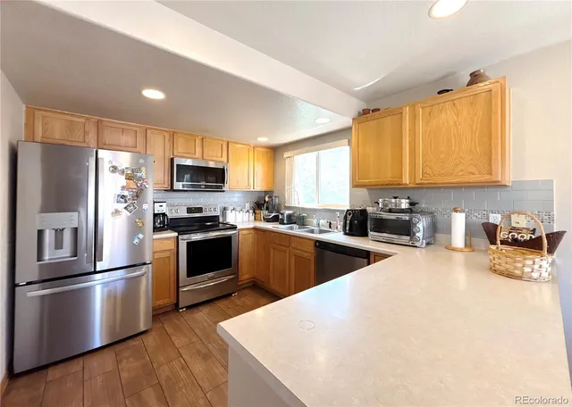 a kitchen with granite countertop a refrigerator stove top oven and sink