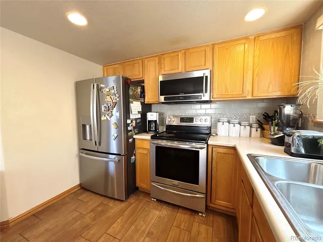 a kitchen with stainless steel appliances granite countertop a refrigerator microwave and sink