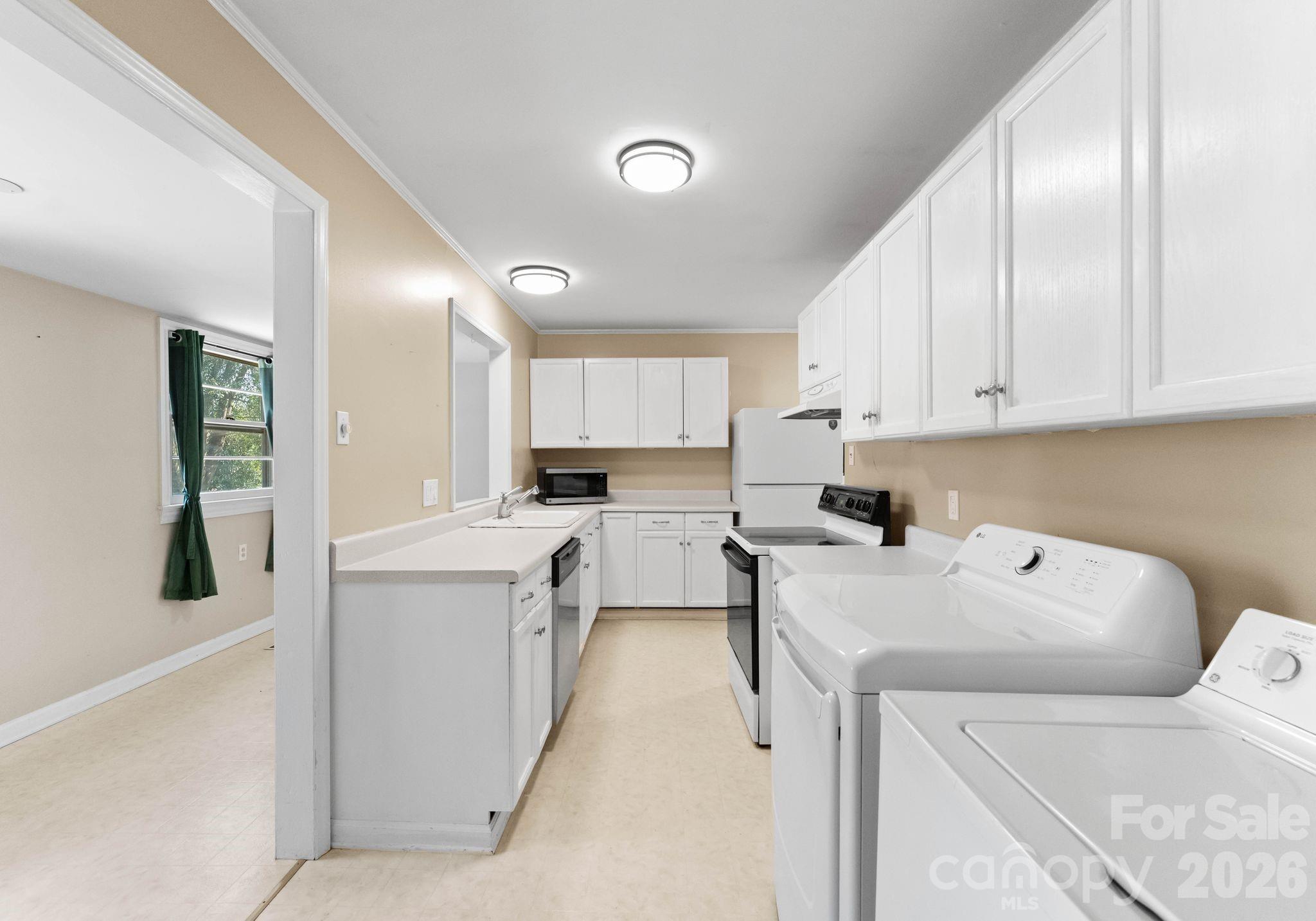 1136 East Woodlawn Road Charlotte, NC 28209 - Photo 11 of 47 a kitchen that has a sink and a stove in it
