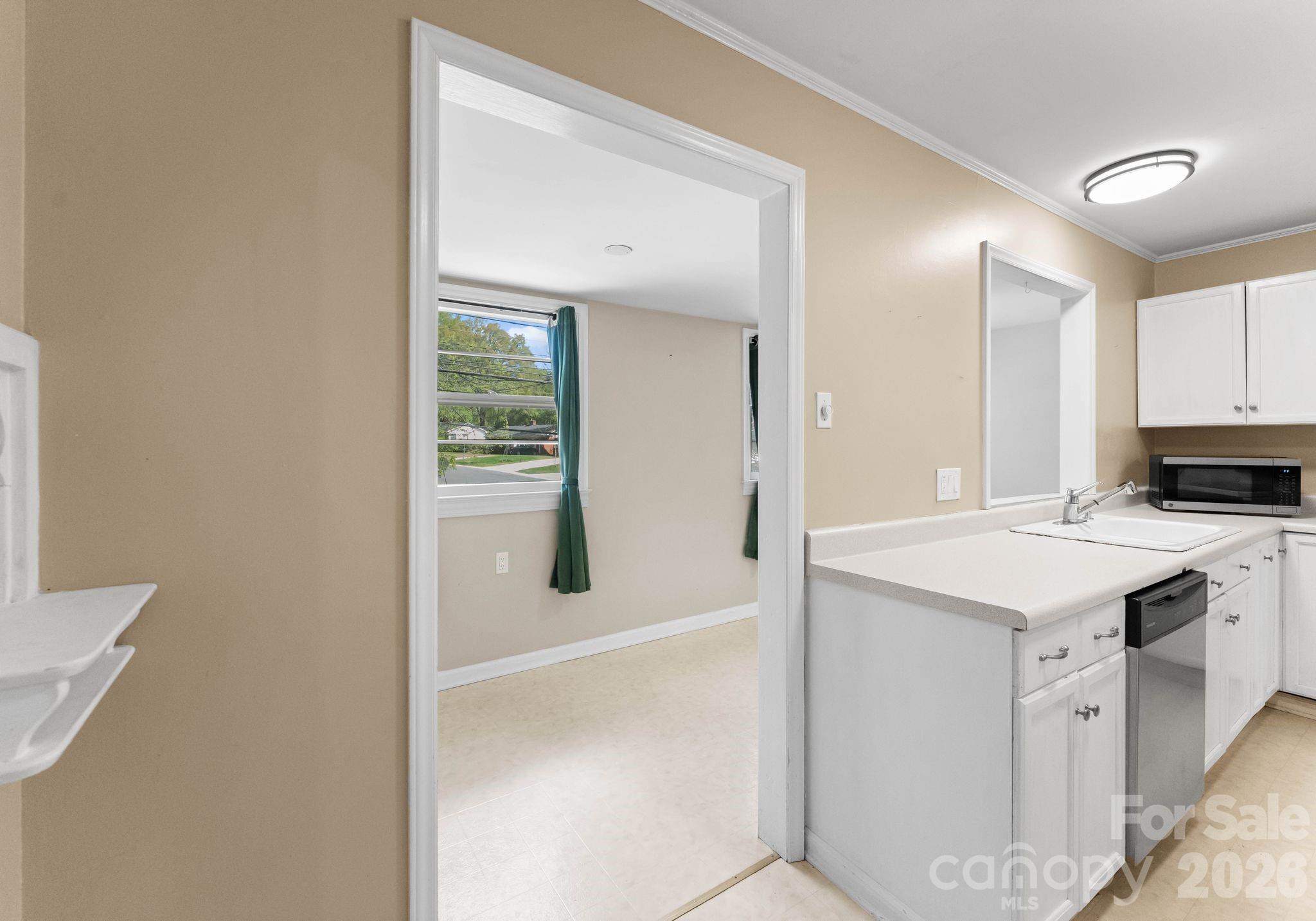 1136 East Woodlawn Road Charlotte, NC 28209 - Photo 12 of 47 a kitchen with kitchen island a sink appliances and cabinets
