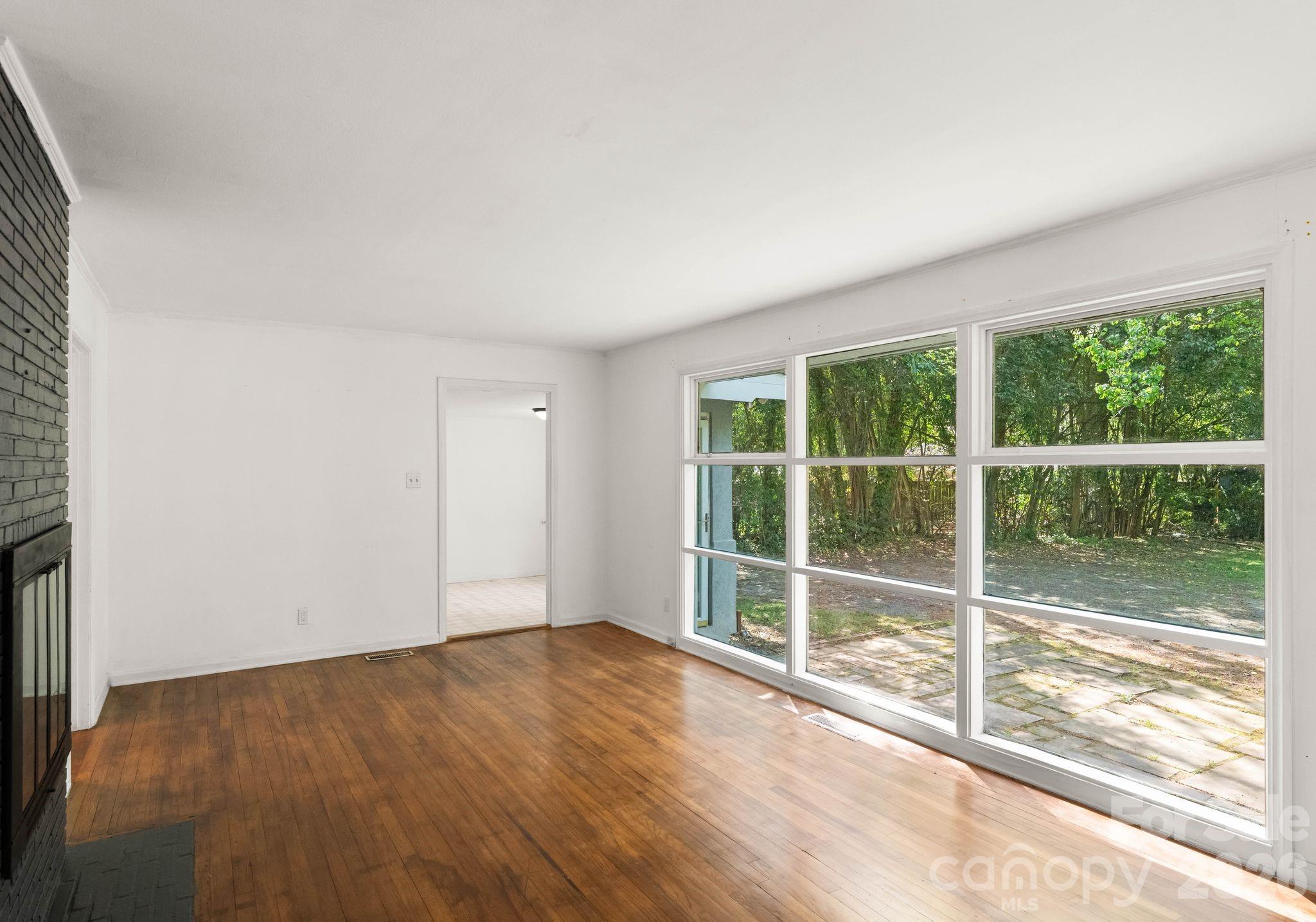 1136 East Woodlawn Road Charlotte, NC 28209 - Photo 18 of 47 a view of empty room with wooden floor and fan