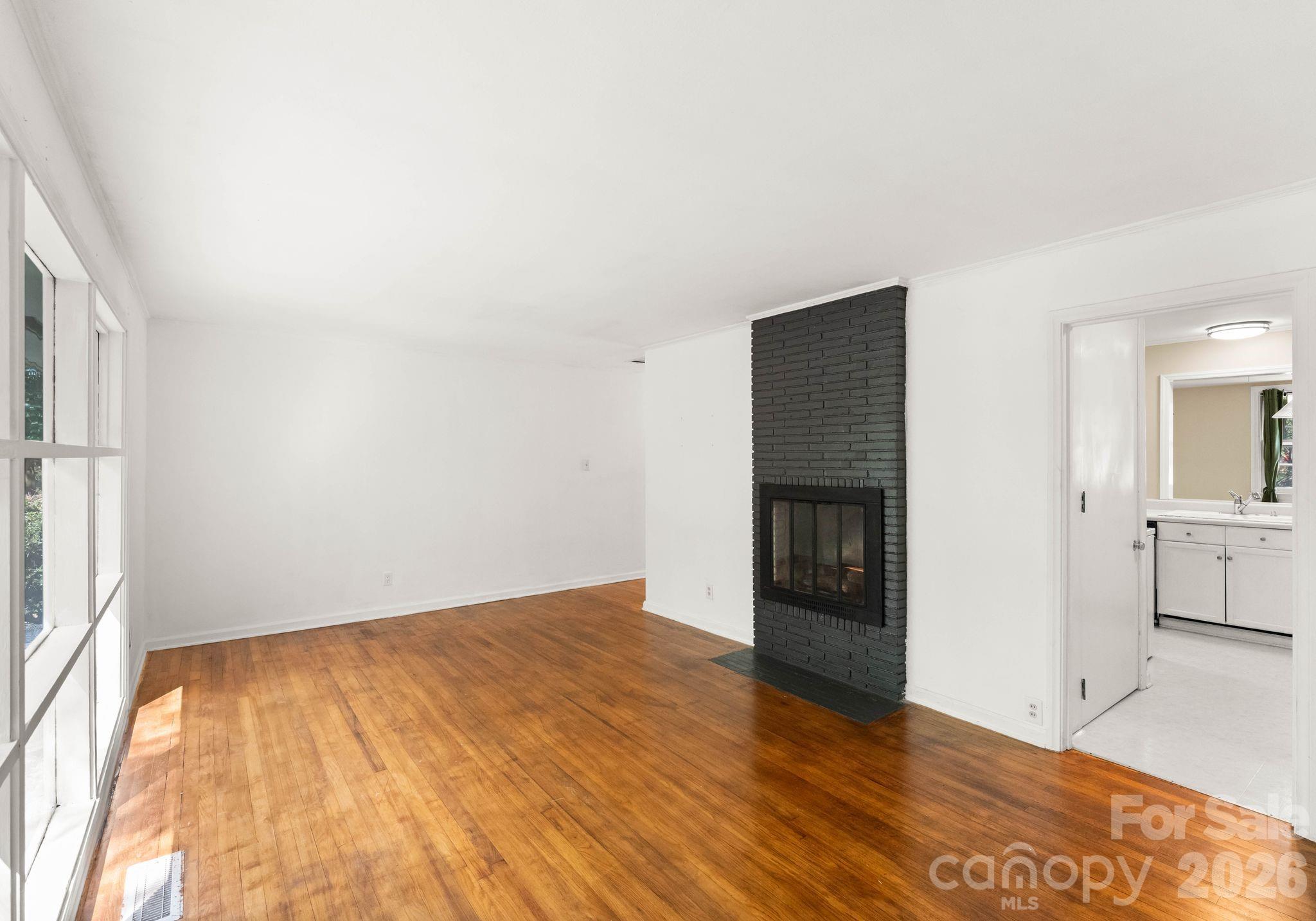 1136 East Woodlawn Road Charlotte, NC 28209 - Photo 20 of 47 wooden floor in an empty room with a fireplace