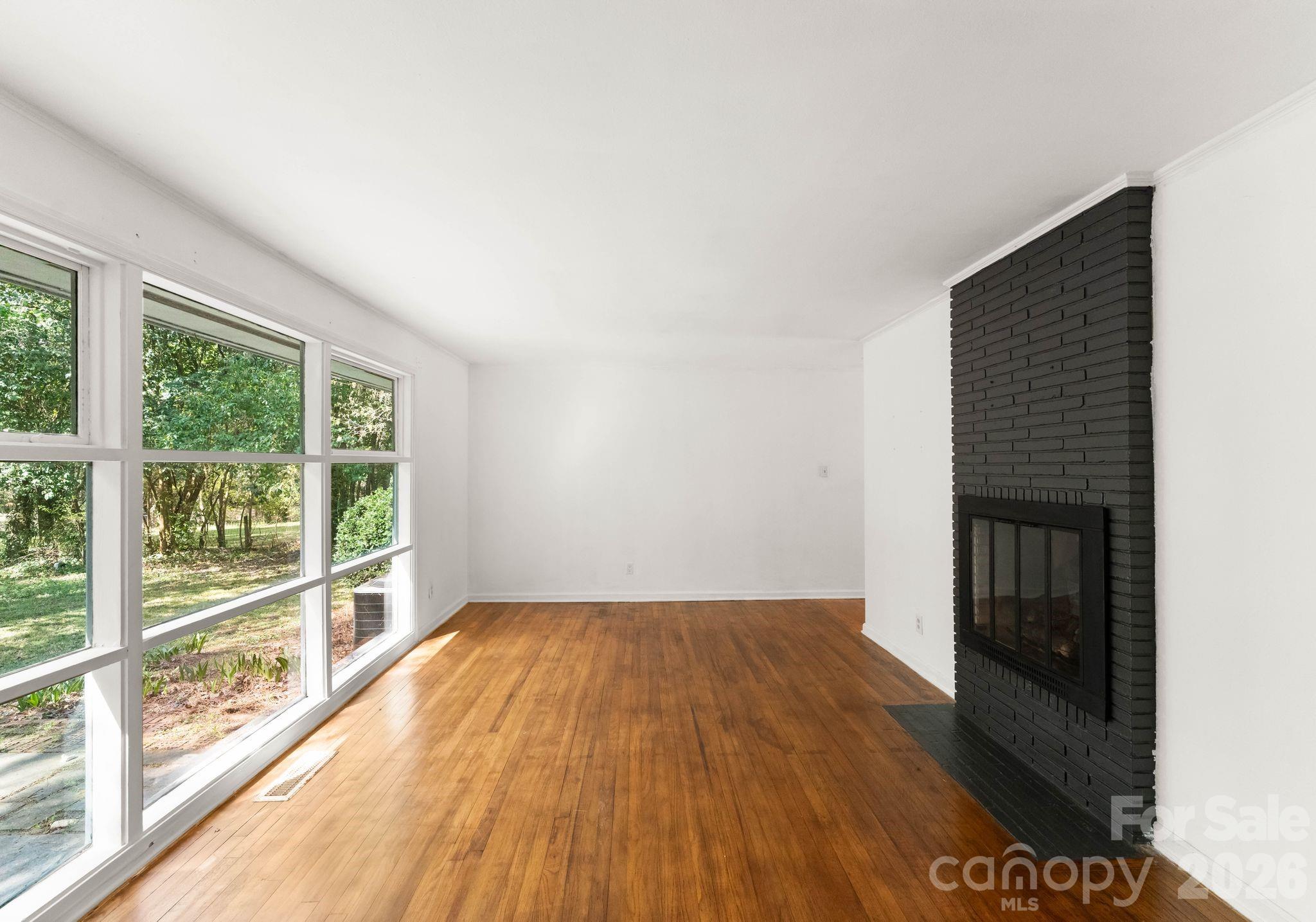 1136 East Woodlawn Road Charlotte, NC 28209 - Photo 21 of 47 a view of empty room with wooden floor and fan