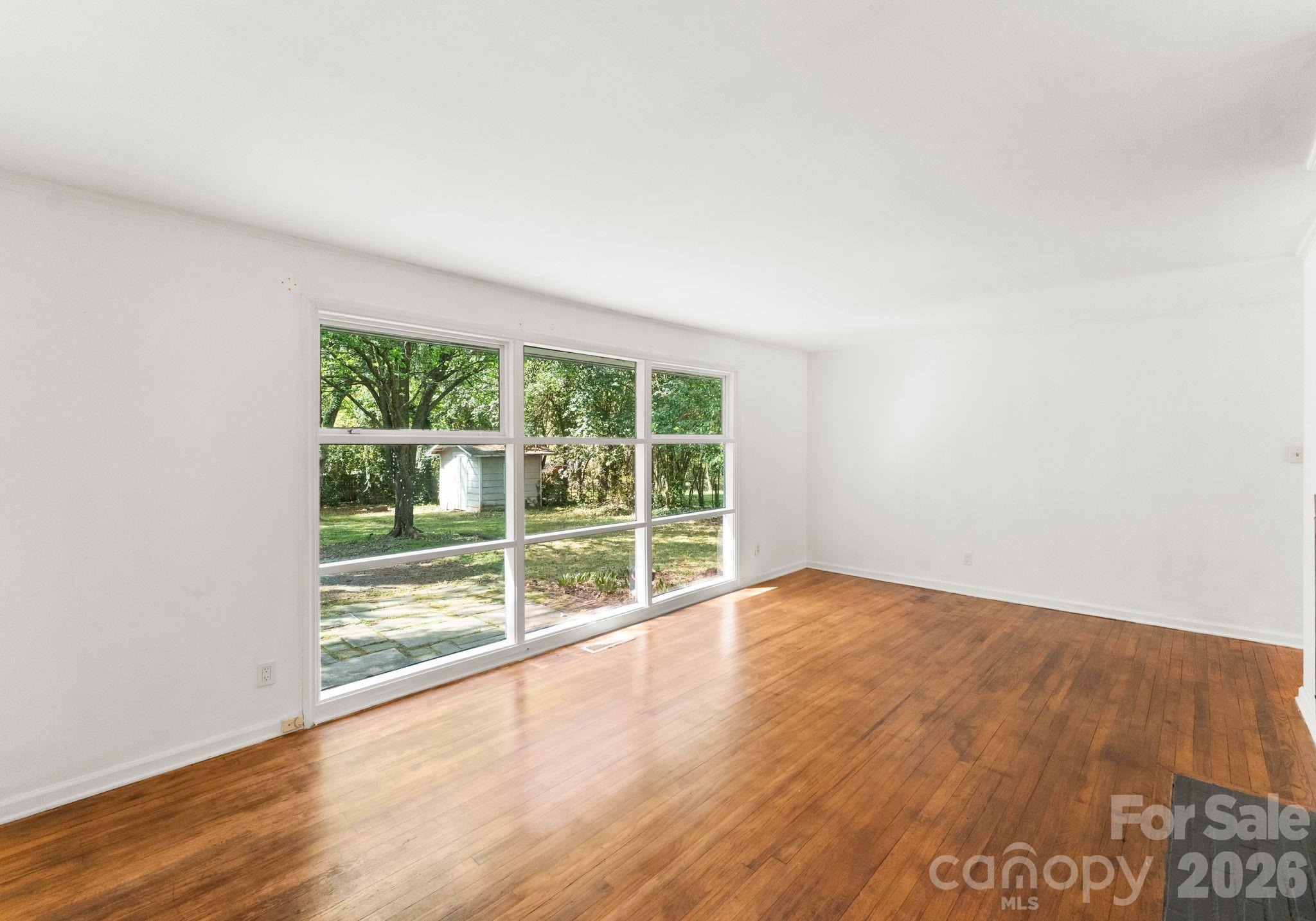 1136 East Woodlawn Road Charlotte, NC 28209 - Photo 22 of 47 a view of an empty room with wooden floor and a window