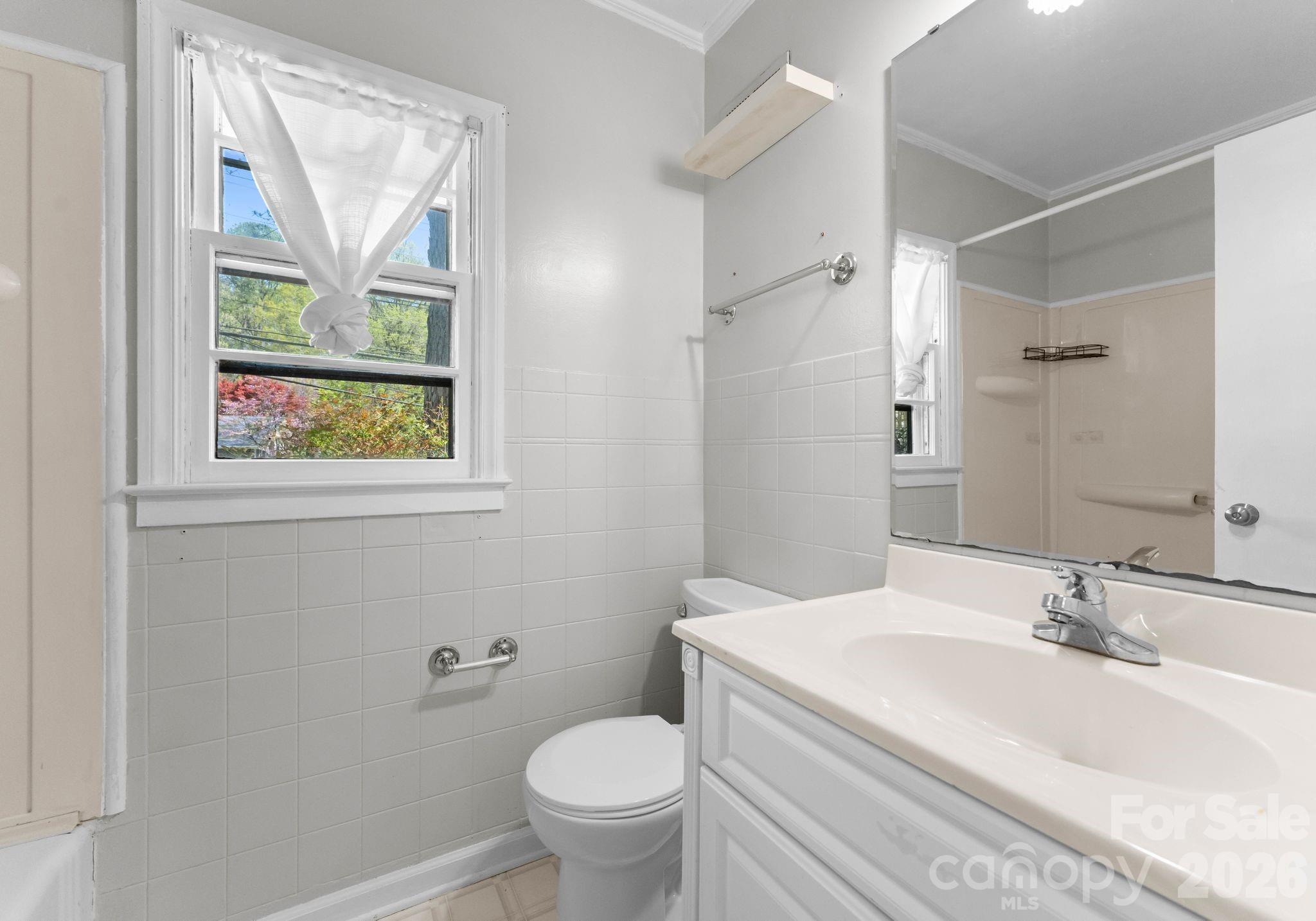 1136 East Woodlawn Road Charlotte, NC 28209 - Photo 29 of 47 a bathroom with a sink toilet and window