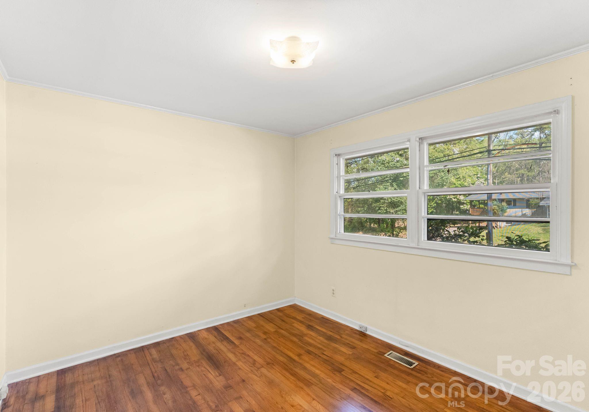 1136 East Woodlawn Road Charlotte, NC 28209 - Photo 32 of 47 an empty room with a window