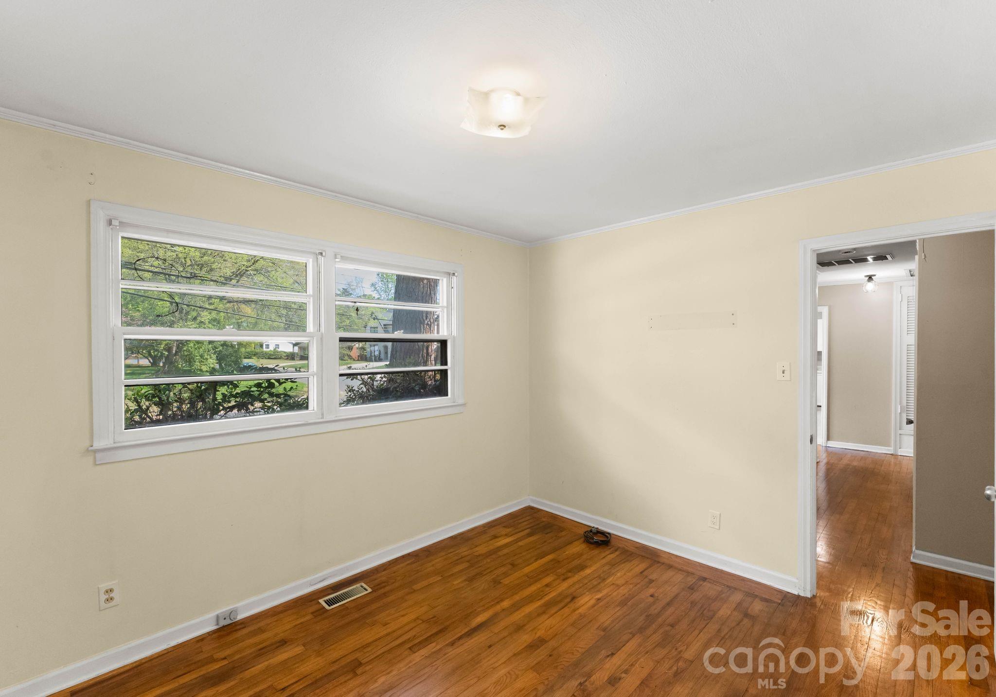 1136 East Woodlawn Road Charlotte, NC 28209 - Photo 33 of 47 a view of an empty room with wooden floor and a window