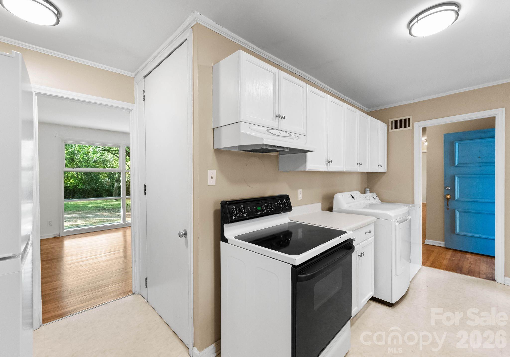 1136 East Woodlawn Road Charlotte, NC 28209 - Photo 4 of 47 a kitchen with white cabinets and stove