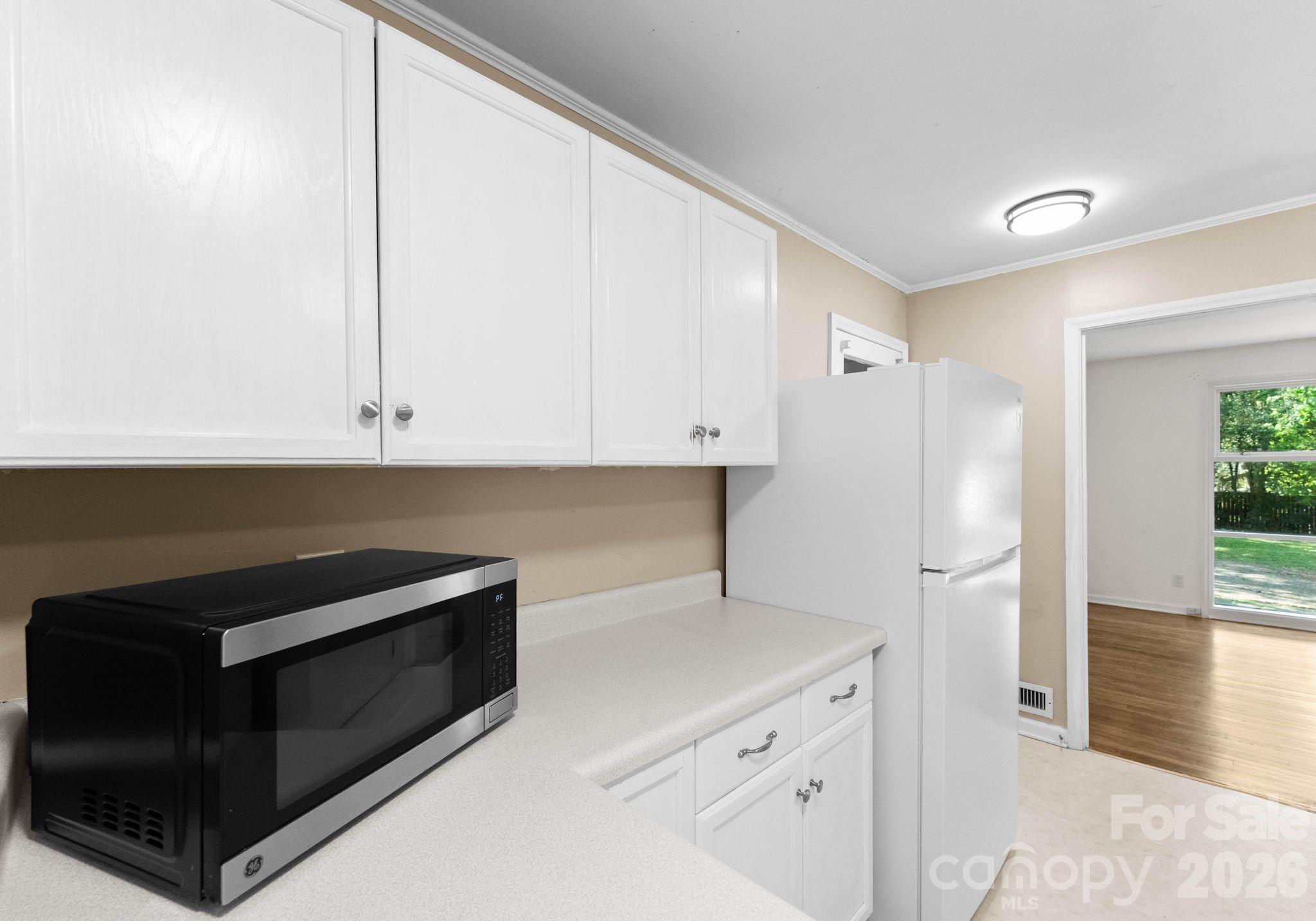 1136 East Woodlawn Road Charlotte, NC 28209 - Photo 6 of 47 a kitchen with stainless steel appliances white cabinets and a refrigerator