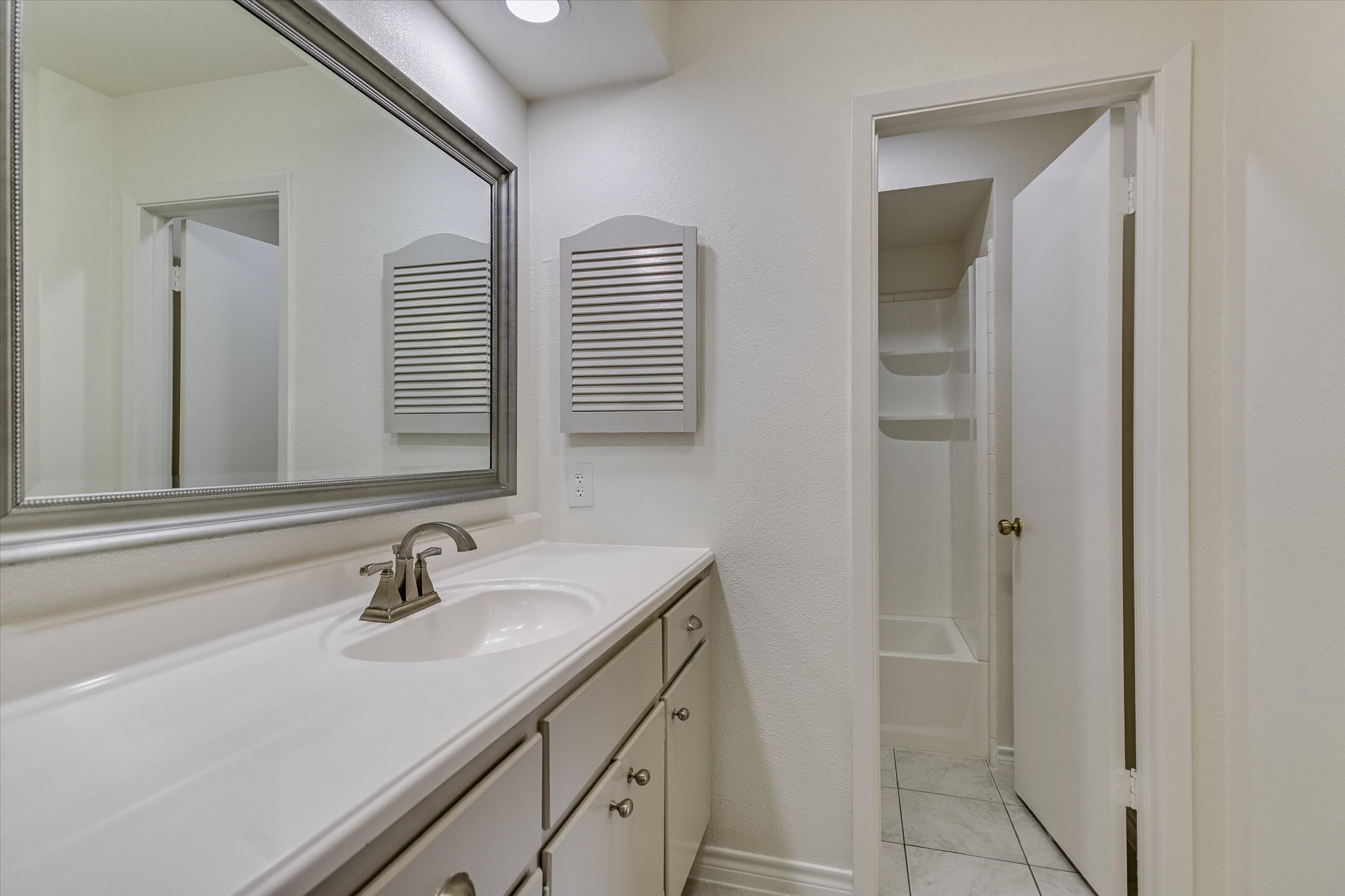 1748 Ohlen Road, Unit 37 Austin, TX 78757 - Photo 10 of 16 Crisp white finishes and a large mirror define this functional bathroom space.