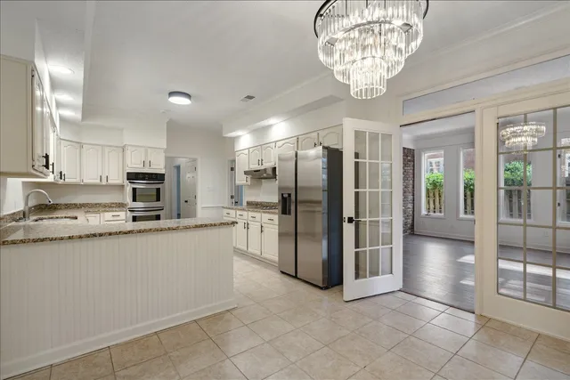a kitchen with stainless steel appliances granite countertop a refrigerator and a sink