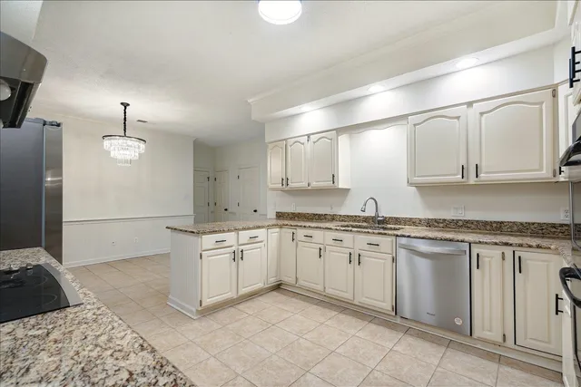 a large kitchen with granite countertop a sink and dishwasher a stove with wooden floor